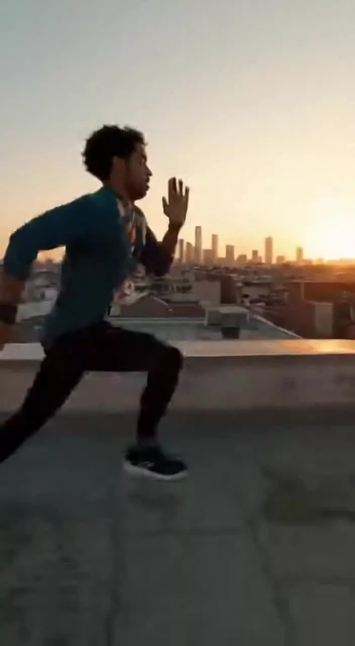 A parkour athlete navigating an urban jungle, leaping between rooftops, vaulting over obstacles, scaling walls. The camera follows with smooth gimbal movements, capturing the fluid athleticism and daring jumps. Sunset lighting, cityscape background, adrenaline and freedom